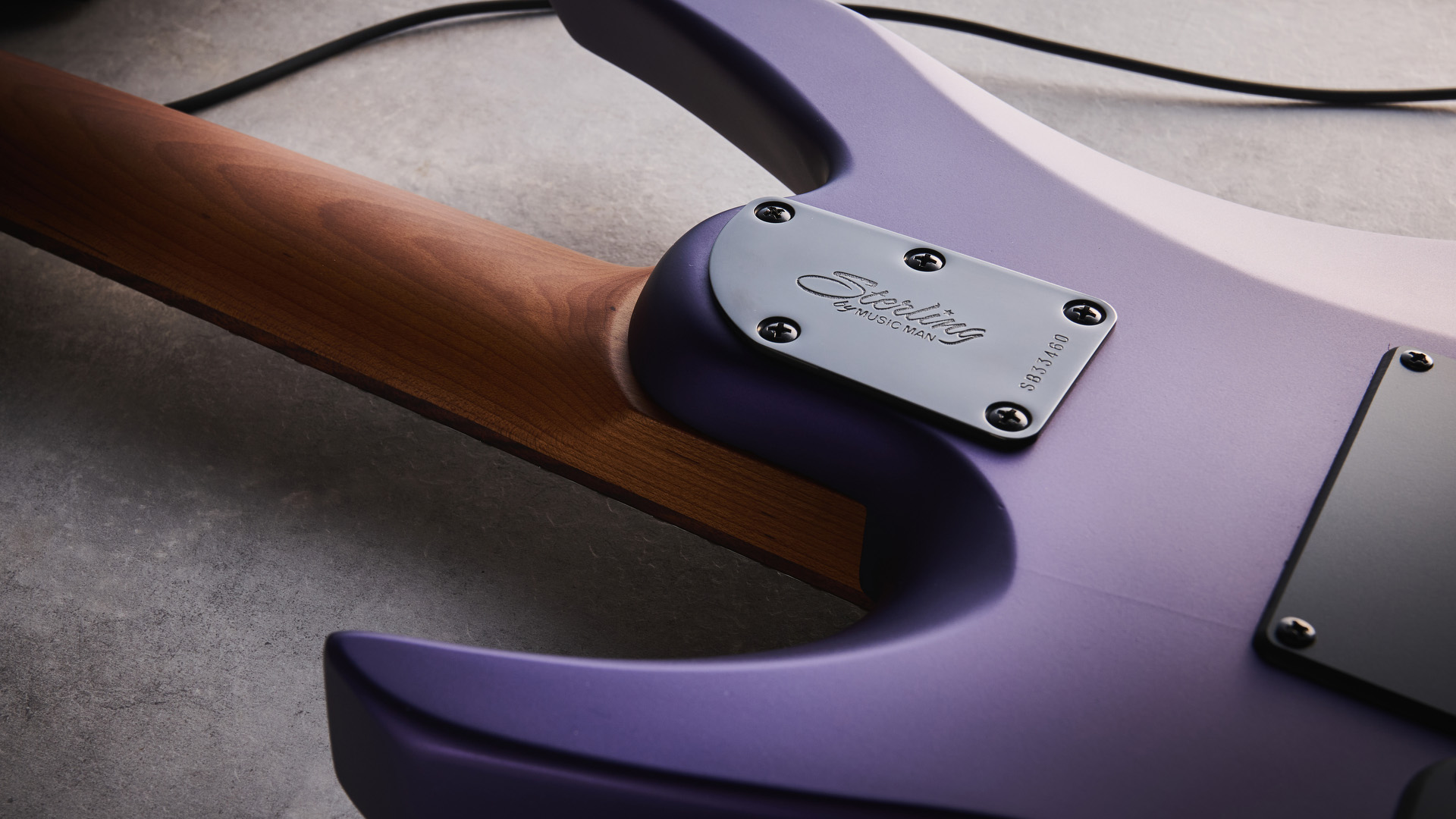 Sterling By Music Man Kaizen 7-string in Firemist Purple Satin, shot in close-up.