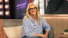 Mel Robbins smiling at the camera in a blue shirt