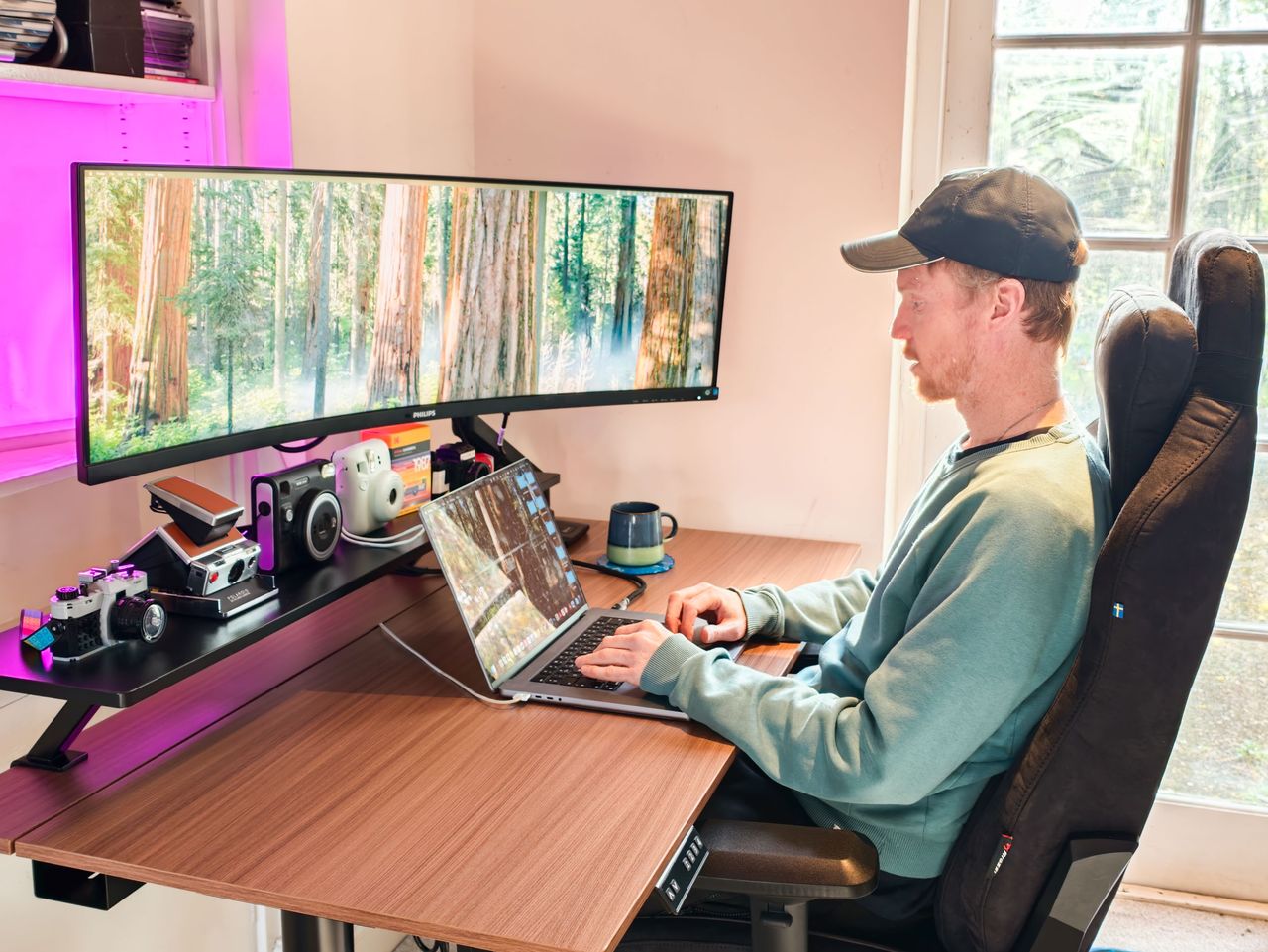 Man sat at the Arozzi Arena Nordico Electric Standing Desk, freshly assembled, in home office room