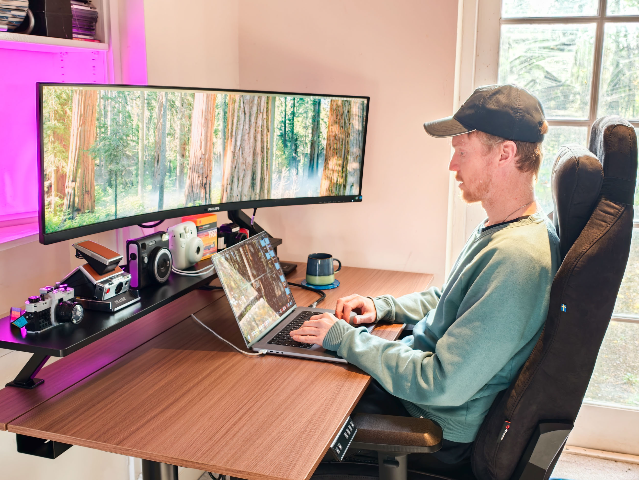 Man sat at the Arozzi Arena Nordico Electric Standing Desk, freshly assembled, in home office room