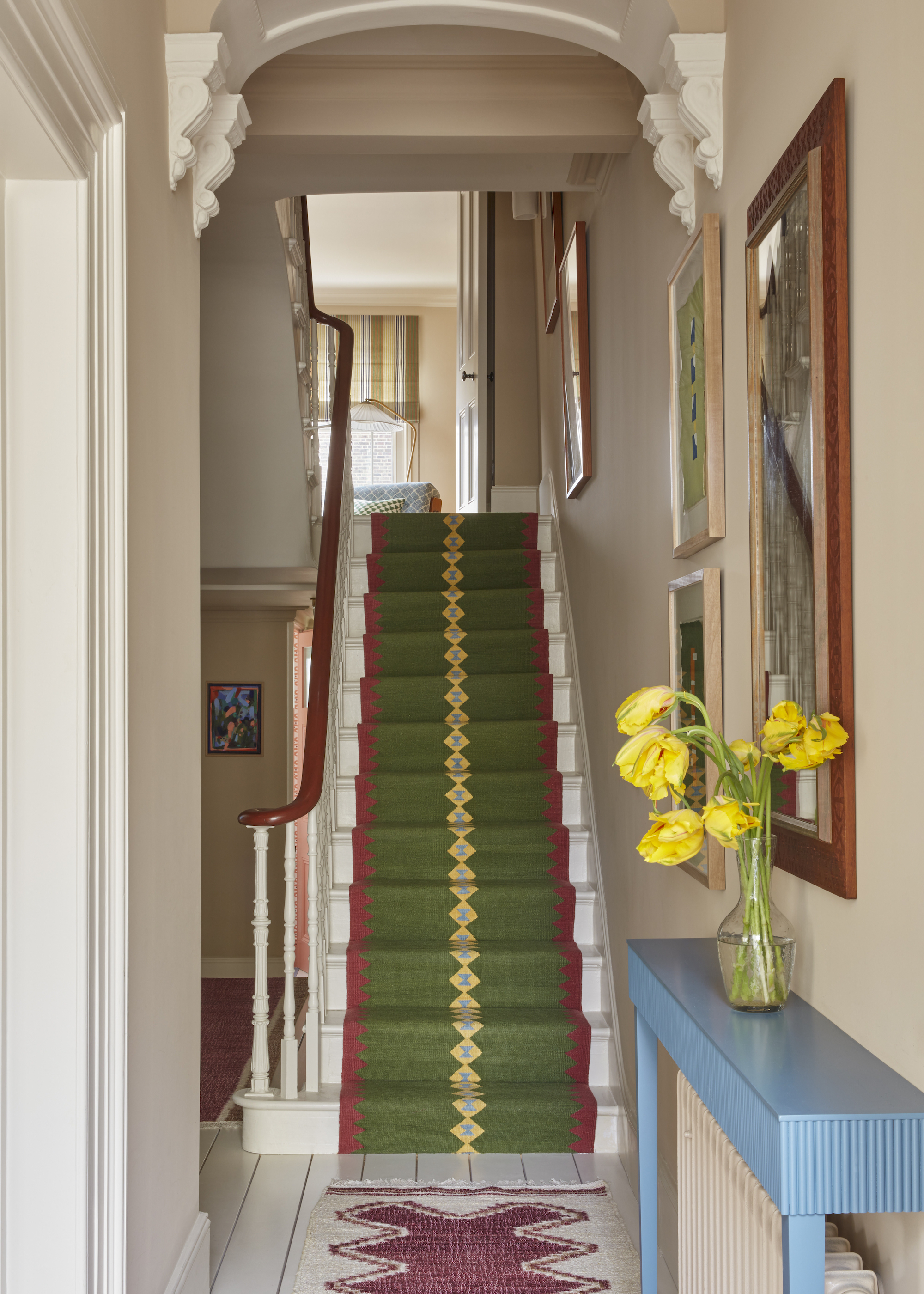 staircase with bright green and dark pink runner