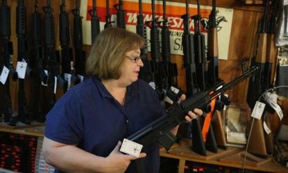 A clerk at Freddie Bear Sports store in Illinois, shows a customer an AK-47 style rifle on Dec. 17.