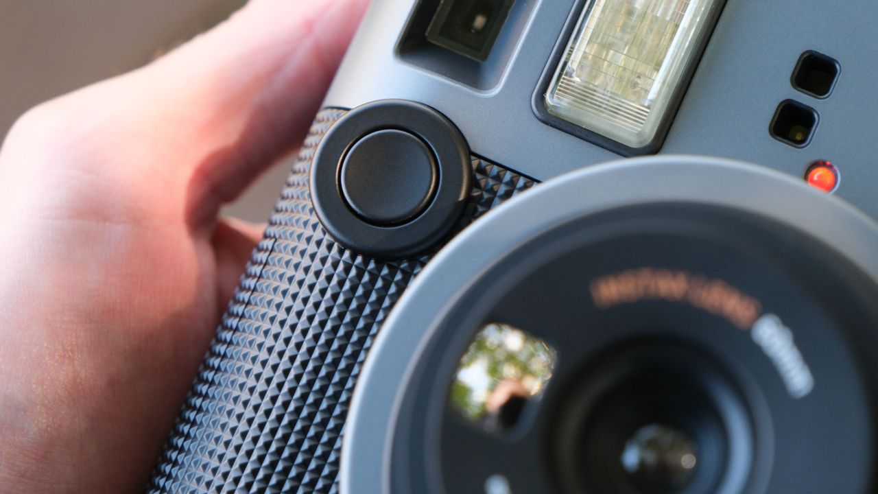 Close up of the shutter button on an Fujifilm Instax Mini 41 camera