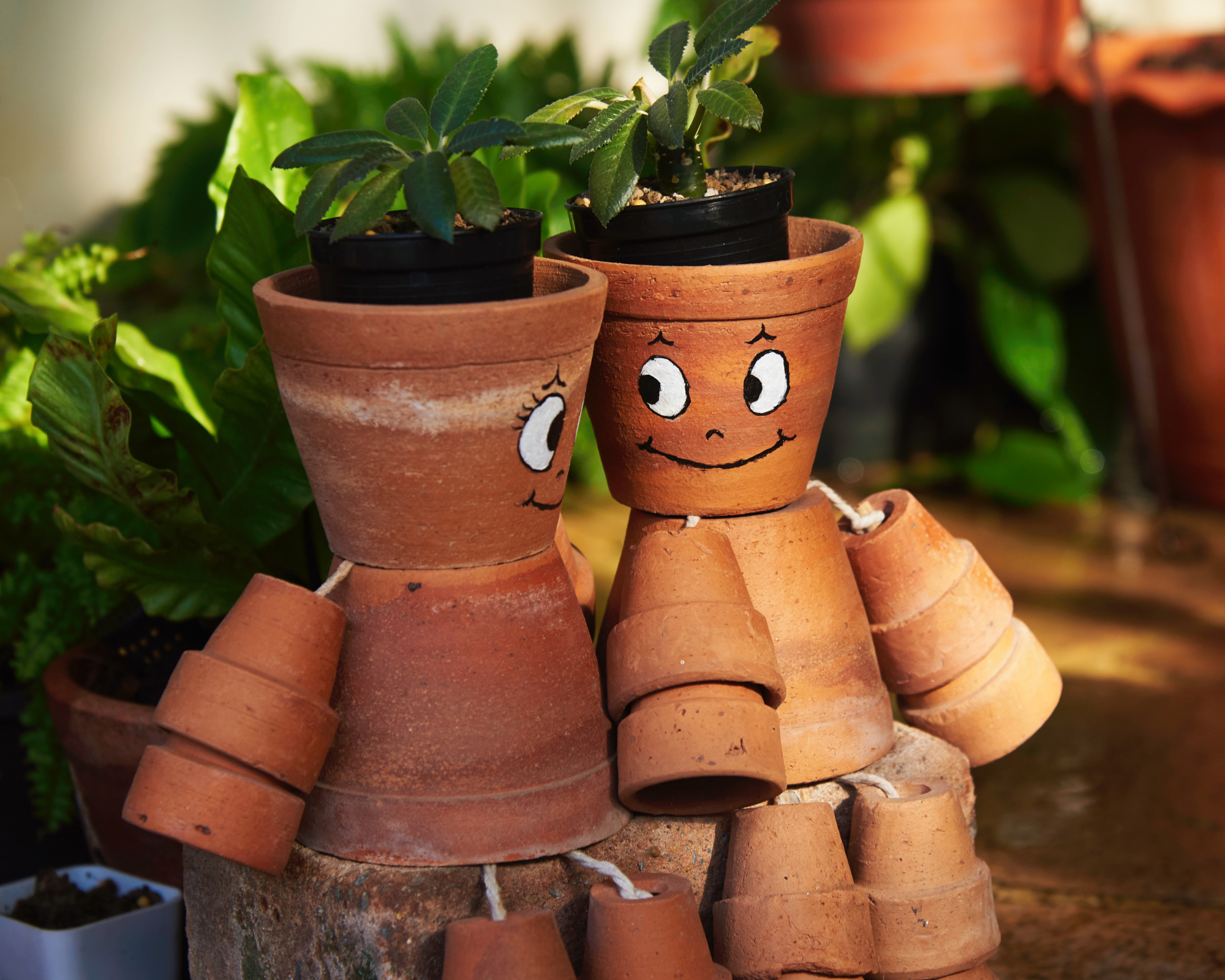 Garden characters created using paint, rope and terracotta plant pots