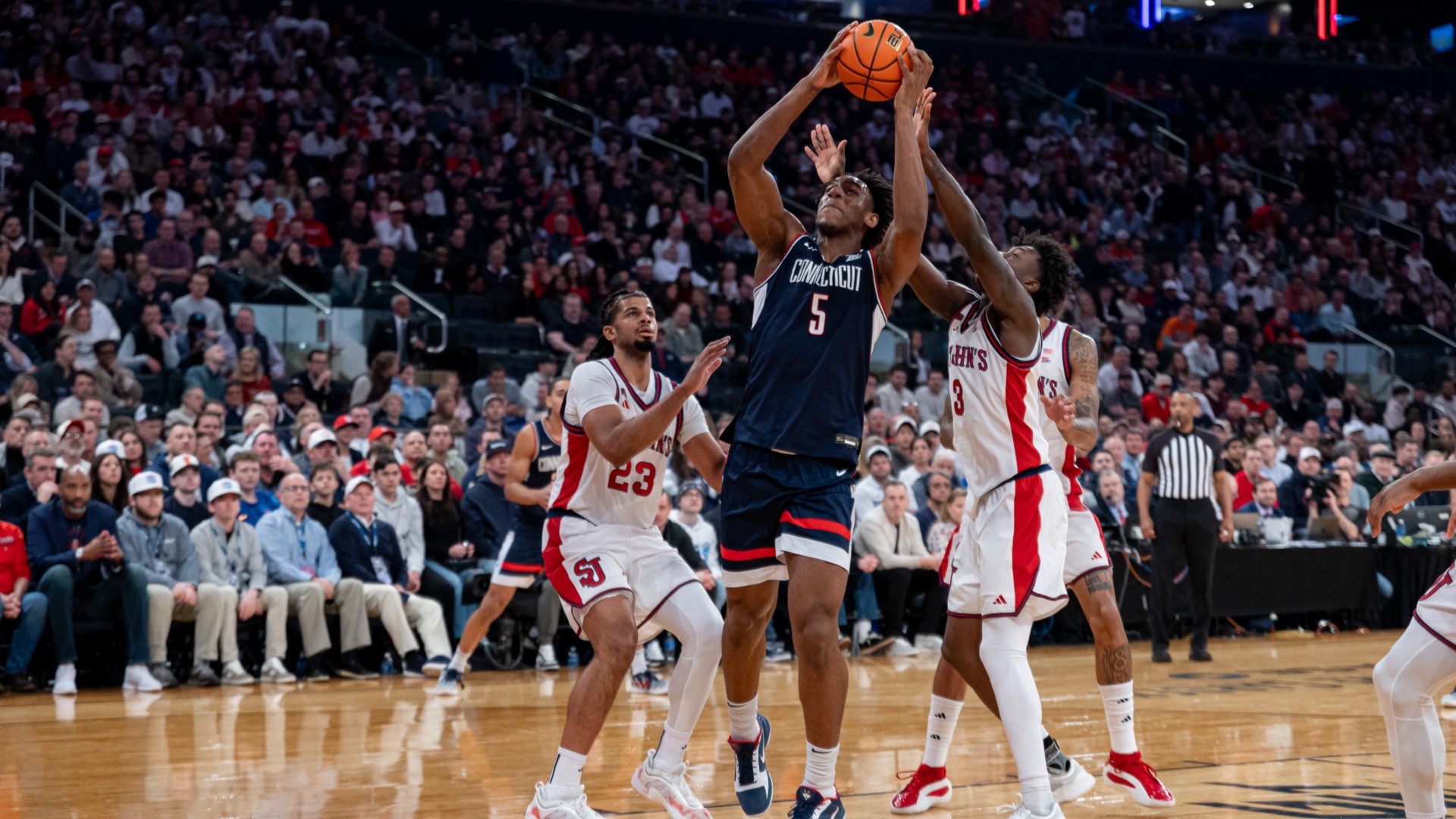 Tarris Reed Jr. of the Connecticut Huskies grabs a rebound against St. John's Red Storm defenders during the BIG EAST Men's Basketball Tournament