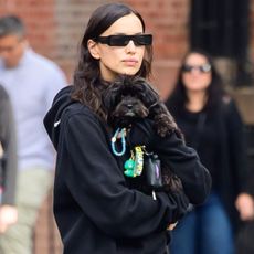 Irina Shayk wears a hoodie and holds her dog