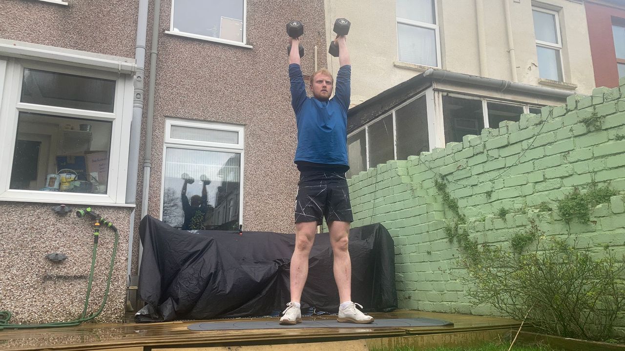 Fit&amp;Well fitness writer Harry Bullmore demonstrating a squat to overhead press
