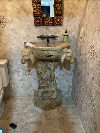 A mosaic tiled powder room with a gothic pedestal sink