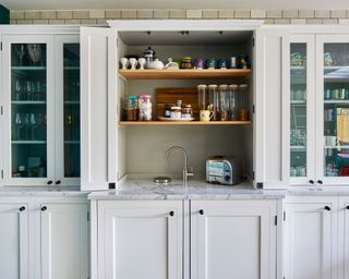 white kitchen cabinetry concealing appliances