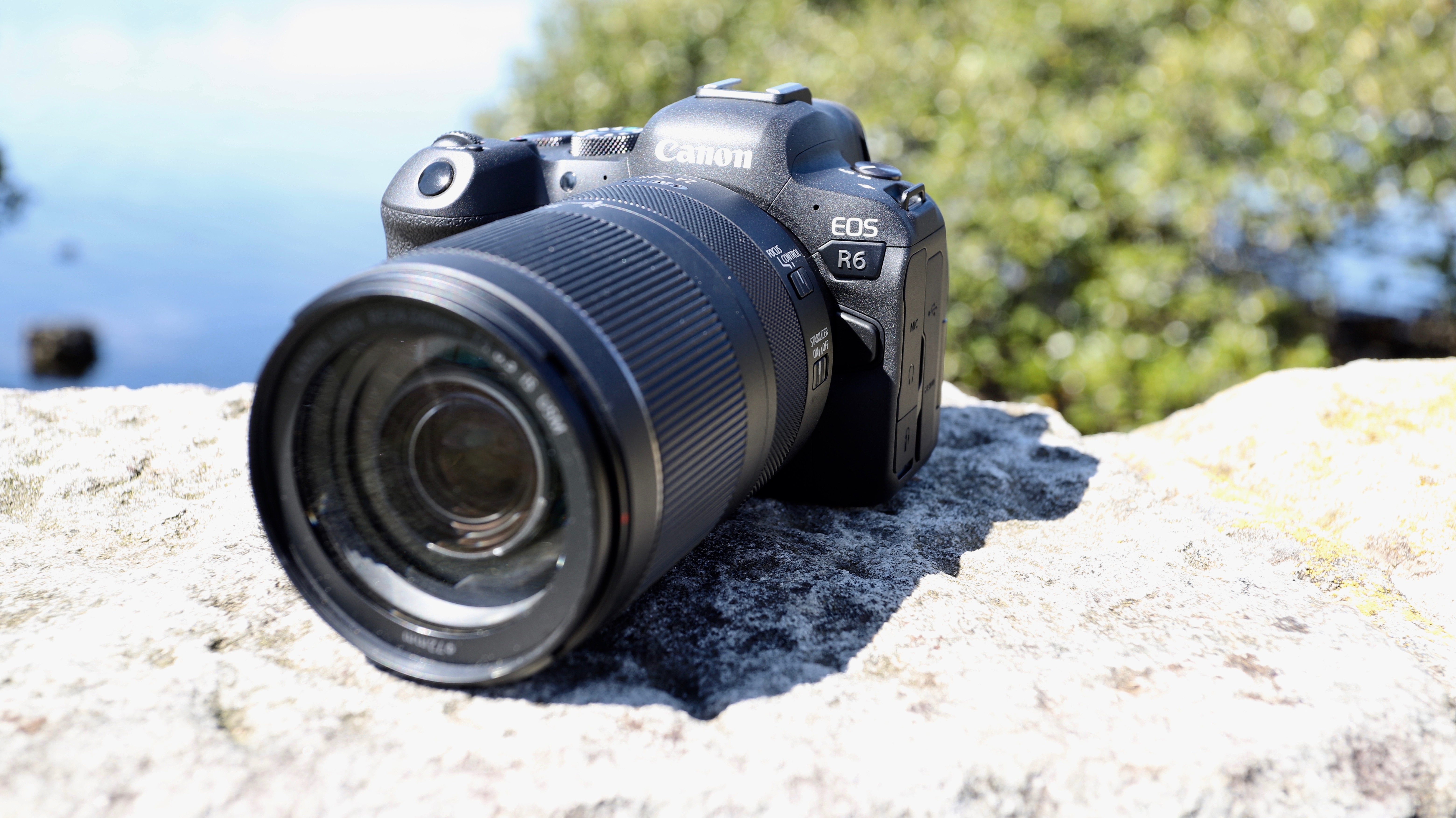 The Canon EOS R6 with a 24-240mm lens resting on a rock