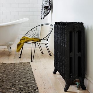 Black radiator in white bathroom