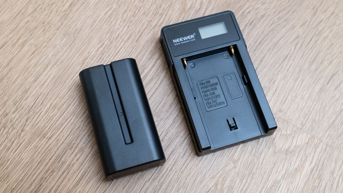 The battery for a Neewer ER1 Motorized Carbon Fiber Camera Slider on a wooden surface