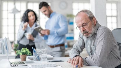 A senior businessman working in his modern office
