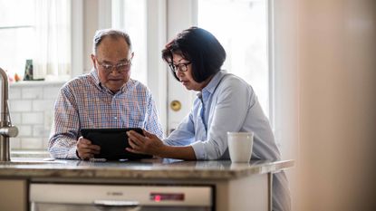 Photo of retired couple looking at tablet figuring out their retirement income