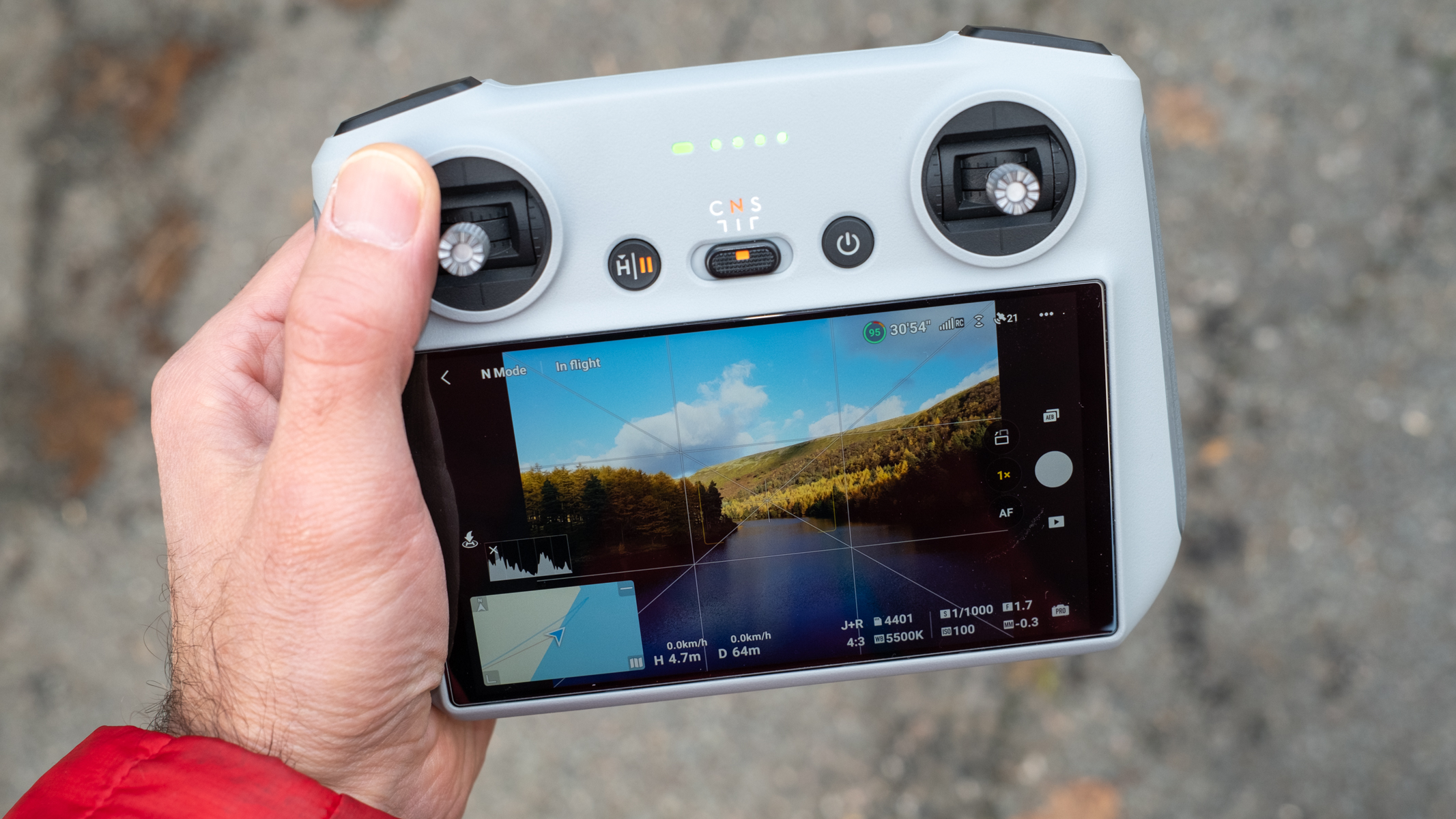 DJI RC held in the drone pilot's hand during a drone flight