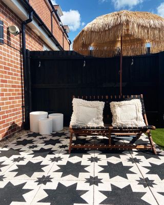 patio with monochrome stencilled floor tiles and a straw parasol