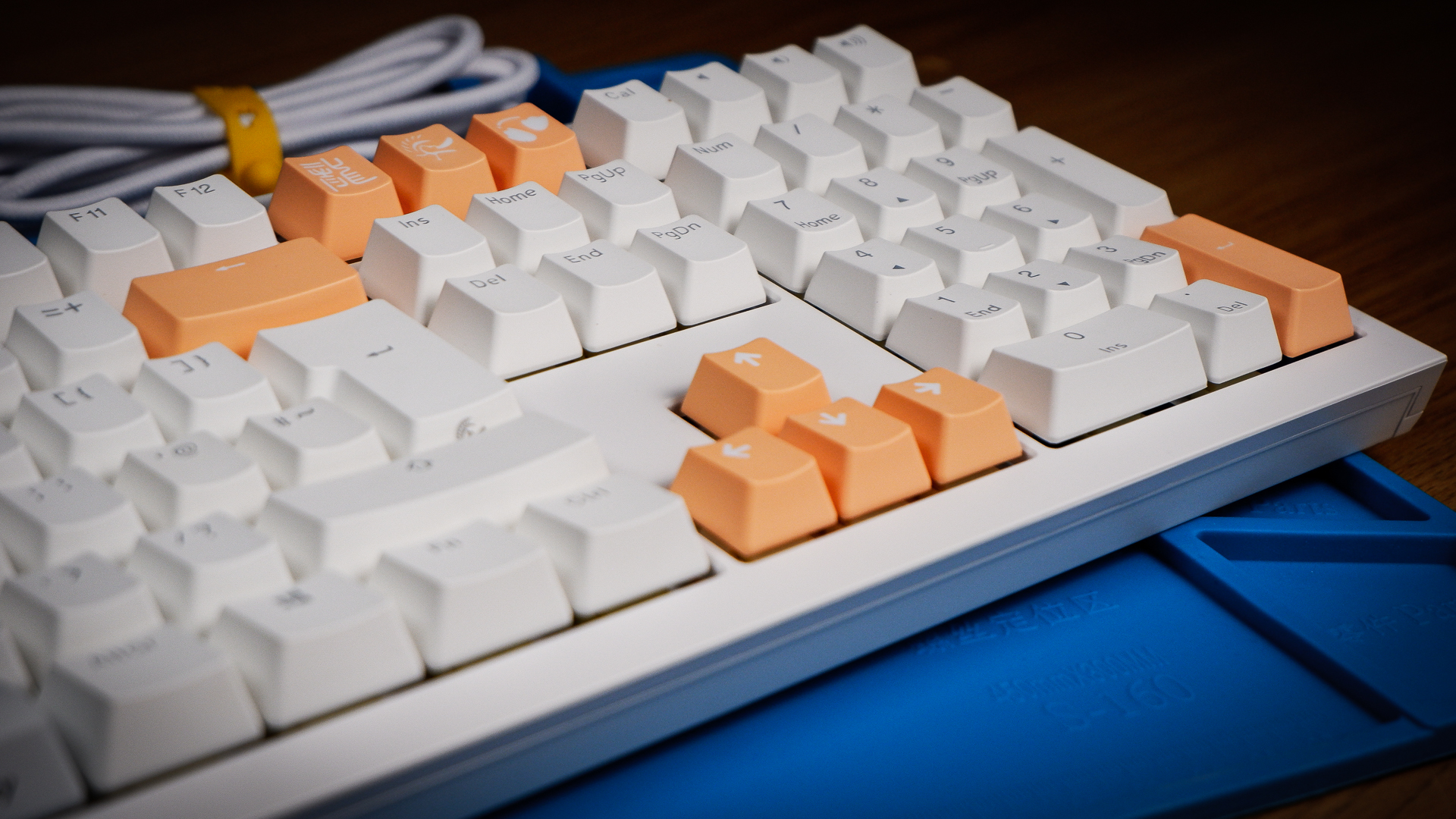 The Ducky One X induction gaming keyboard on a blue mat on a desk, with keycaps removed.