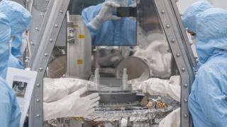 OSIRIS-REx curation team members at NASA’s Johnson Space Center begin the process of removing and flipping the TAGSAM (Touch-and-Go Sample Mechanism) from the avionics deck of the mission's science canister.