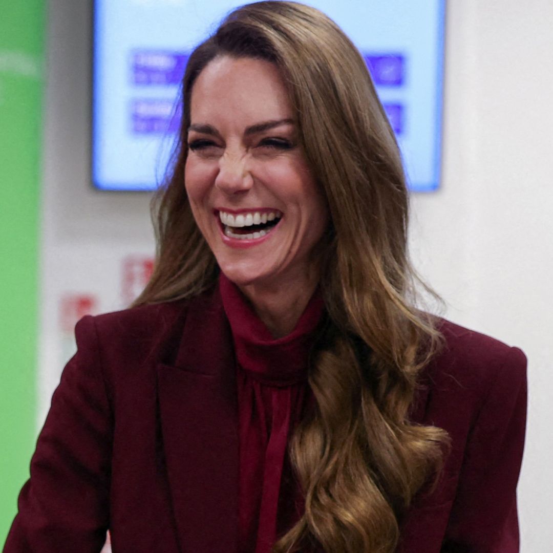 Princess Kate wearing a burgundy suit and laughing