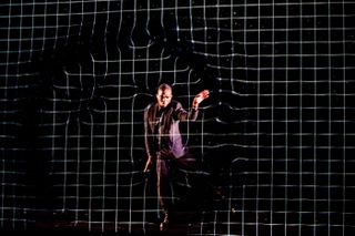 Movement specialist Drew Dollaz performs a choreographed dance in sync with a graphic of ripples moving through a mesh that represents the fabric of space-time. This scene was featured in the 2019 production of "Light Falls: Space, Time, and an Obsession of Einstein" in New York City on May 22.