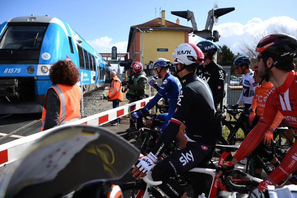 The peloton stopped at a level crossing