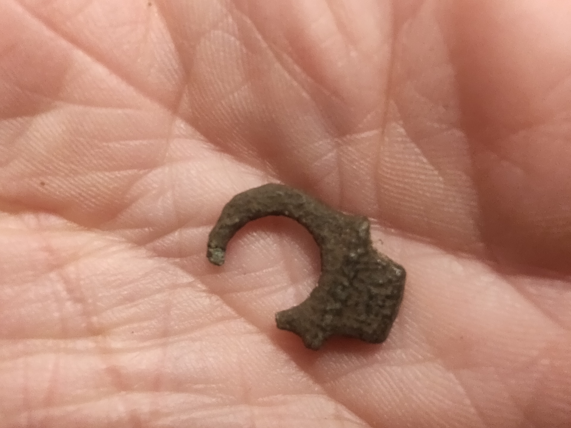 a close-up of a small metal piece in a person's hand