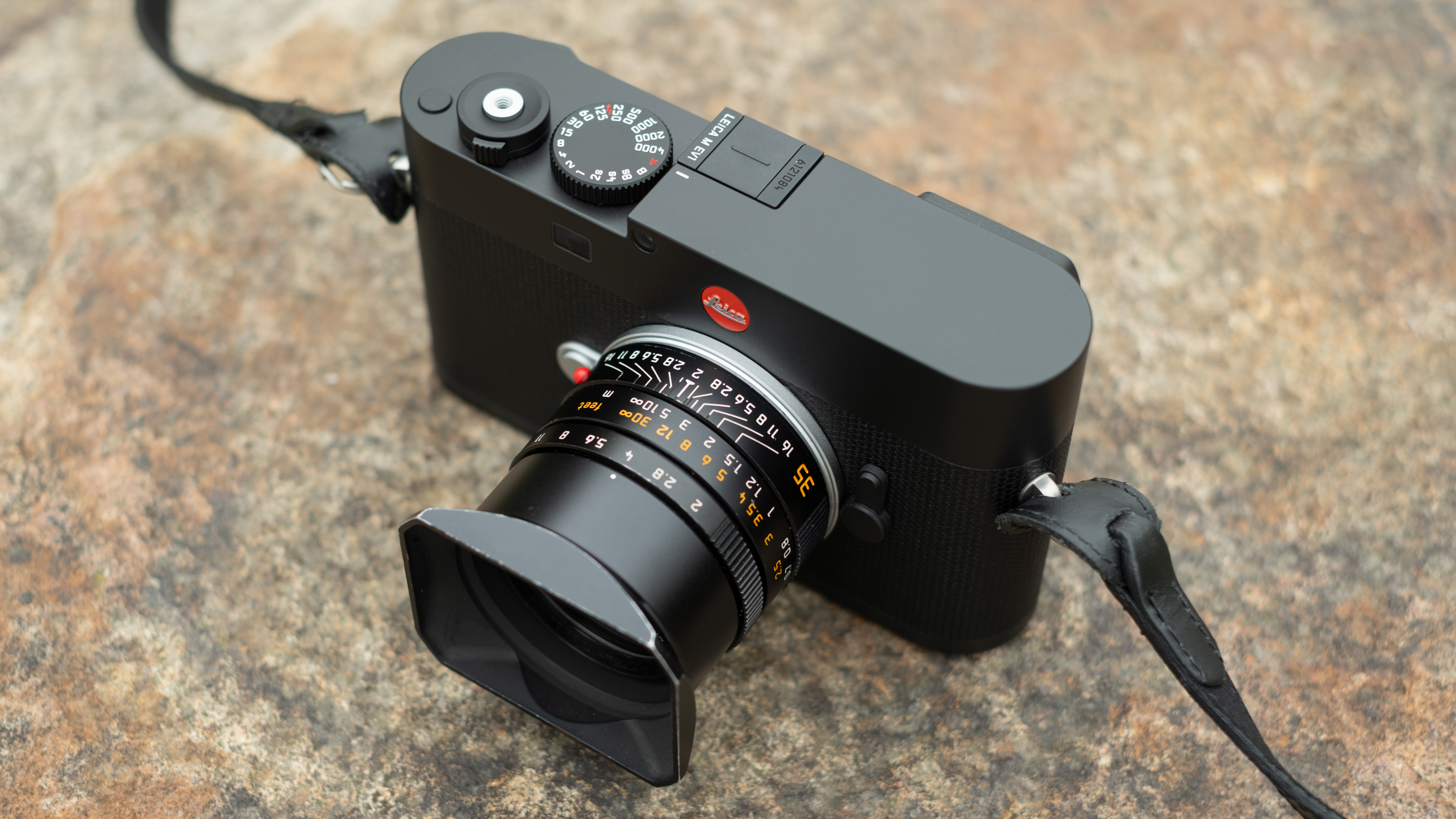 Leica M EV1 digital camera with lens attached on a stone surface