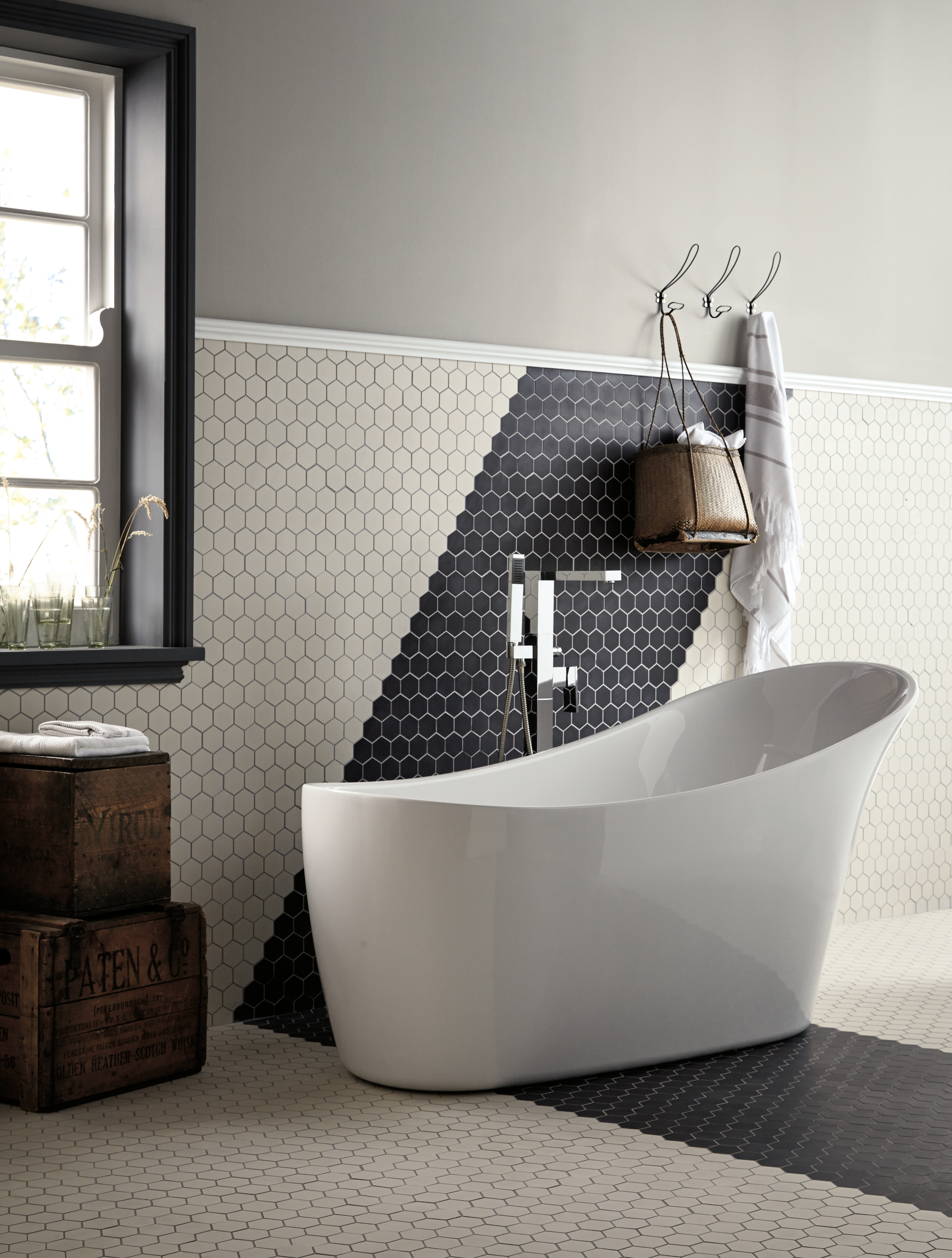 A black and white bathroom with hexagon tiles 