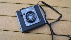 A black and gray Fujifilm Instax Wide Evo hybrid instant camera