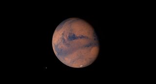 A rusty red planet against a black background of space.