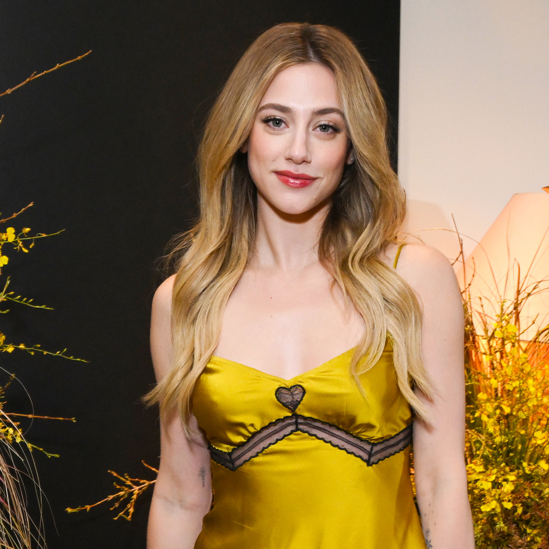 Lili Reinhart wearing a yellow slip dress. her hair is down and curled and she has on a red lip tint. 