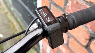 A photo of the Swytch Go e-bike conversion kit OLED display attached to a bicycle