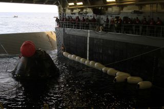 NASA's Orion space capsule is towed into the well deck of the USS Anchorage Navy ship during recovery efforts after the spacecraft's splashdown in the Pacific Ocean on Dec. 5, 2014.