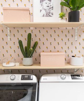 Small laundry room with pretty pastel floral wallpaper and potted cacti