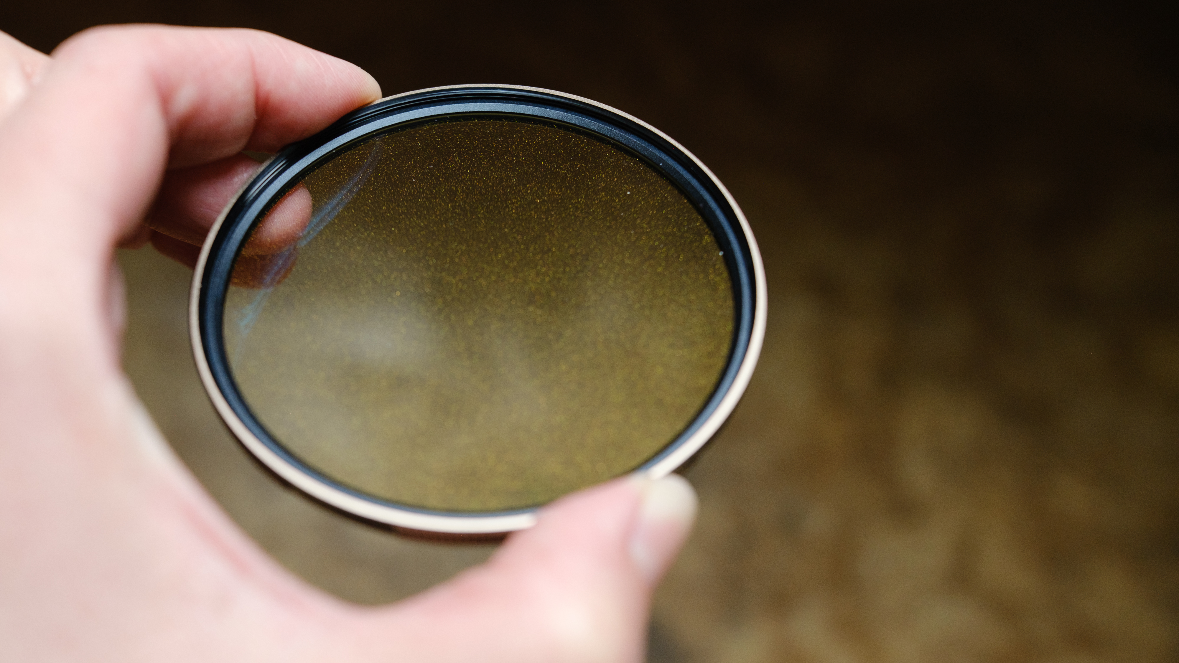The Polar Pro McKinnon 135 Gold Mist filter in a person's hand