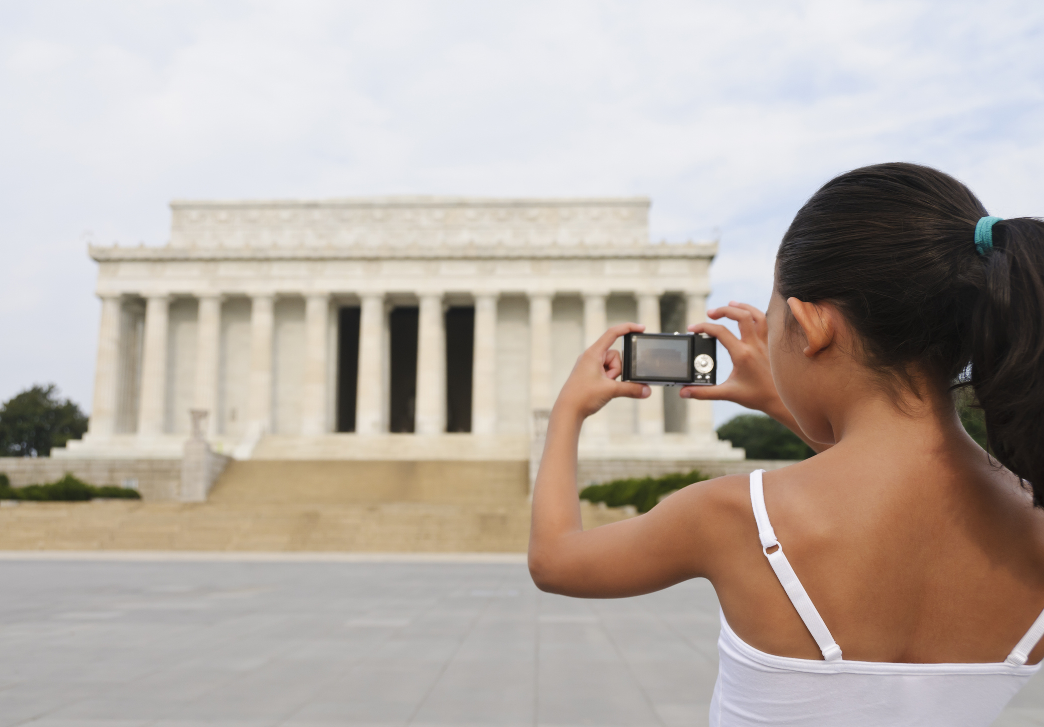A girl takes a picture at the Lincoln Memorial.