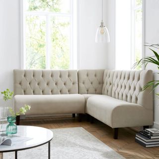 A cream upholstered banquette seat in an L-shaped configuration 