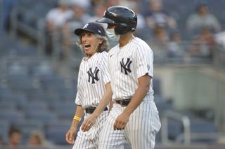 70-year-old honorary bat girl Gwen Goldman reacts after delivering baseballs to home plate umpire Scott Barry #87 during the first inning against the Los Angeles Angels at Yankee Stadium on June 28, 2021 in the Bronx borough of New York City.