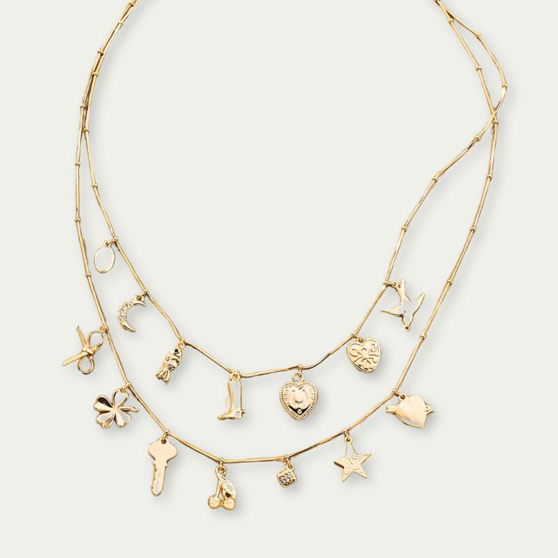 A cutout of a gold layered charm necklace