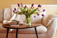 In a living room, a vase with tulips placed inside