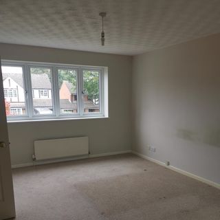 an empty bedroom with no furniture or curtains and dirty carpet