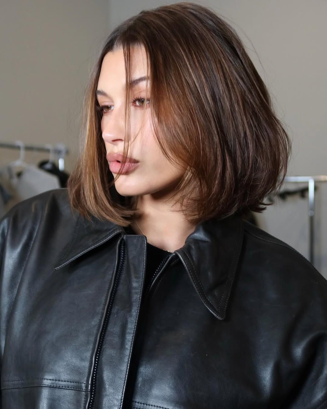 Hailey Bieber wears a chocolate luxe bob with an oversized leather jacket