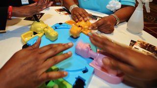 Women playing the Hungry Hungry Hippos game