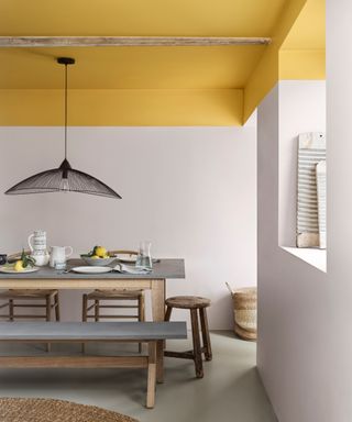 Basement with painted yellow ceiling, large pendant