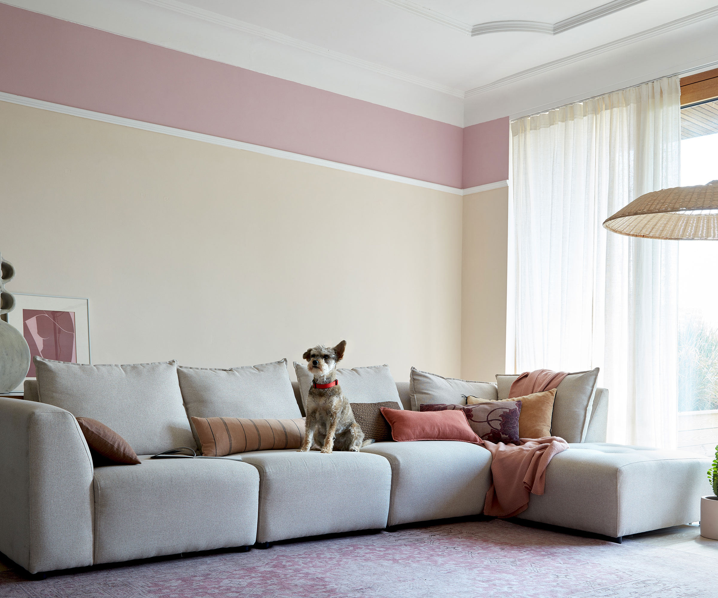 pink and white living room with large grey modular sofa