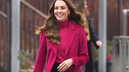Britain's Catherine, Duchess of Cambridge gestures as she arrives for a visit to Nower Hill High School in Harrow, north London