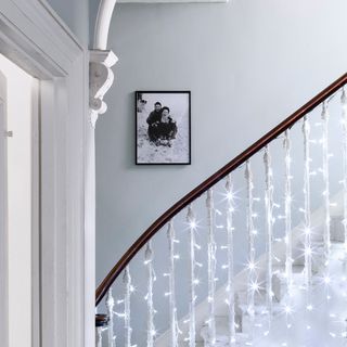 Fairy lights on staircase banister in a hallway