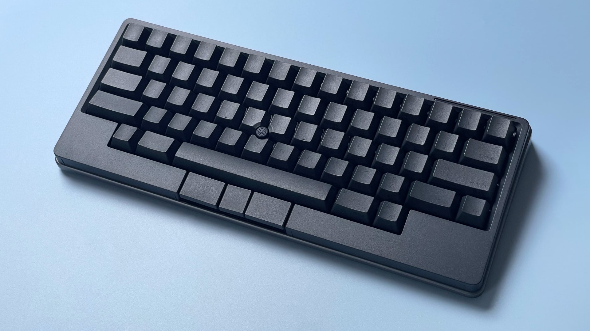 The HHKB Studio mechanical keyboard against a blue background.