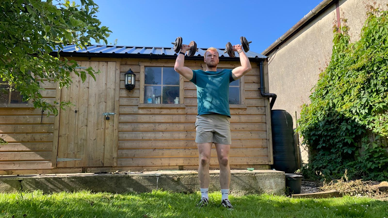 TechRadar fitness writer Harry Bullmore performing a dumbbell shoulder press