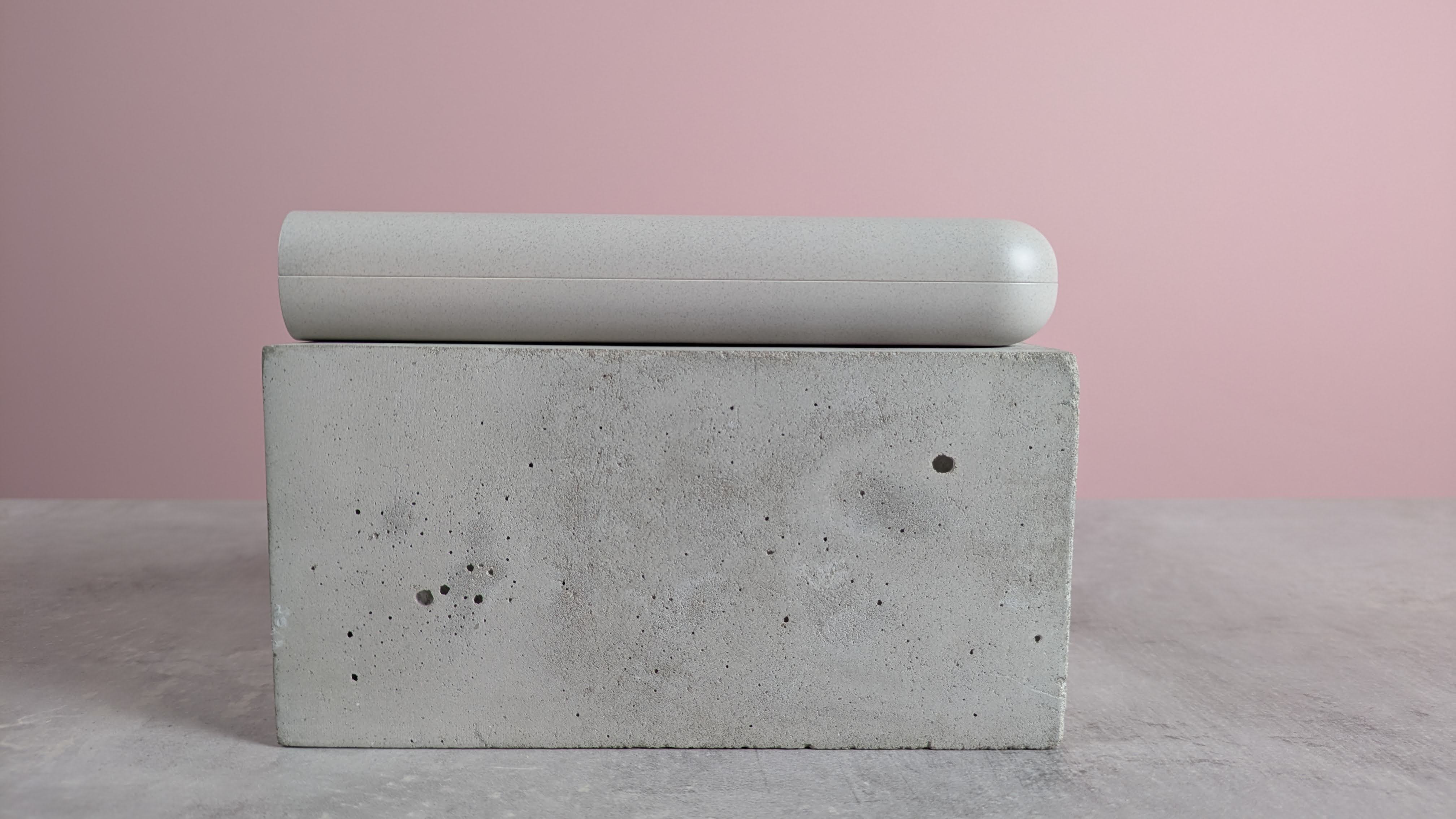 Side view of Samsung 45W 20000mAh Battery Pack, on plinth on desk with pink background